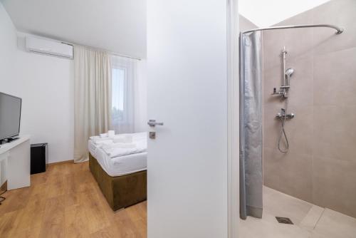 塞尔瑟Beach Villa Selce的带淋浴的浴室和1张床