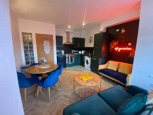 a living room with a blue couch and a table at City Apartment - Sleeps 4 & Free Parking in Belfast