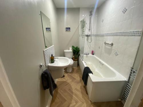 a bathroom with a tub and a toilet and a sink at City Apartment - Sleeps 4 & Free Parking in Belfast