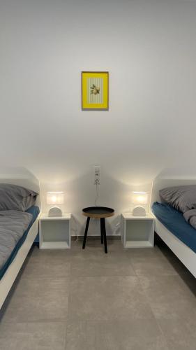une chambre avec deux lits et une table dans l'établissement Frisch saniert, Moderne Ferienwohnungen für 1 bis 37 Personen, Warme Weihnachten, à Böbingen an der Rems