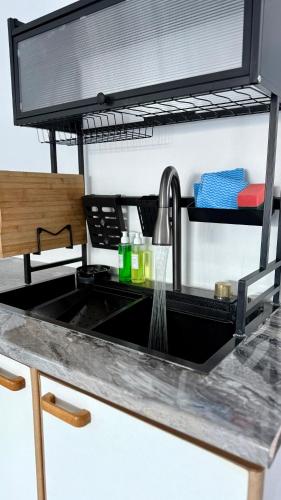 a kitchen counter with a sink with a faucet at The White House - Zonnebloem in Cape Town