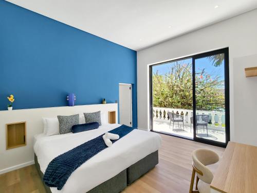 a bedroom with a large bed with a blue wall at Palm Paradise - Boutique Guest House in Cape Town