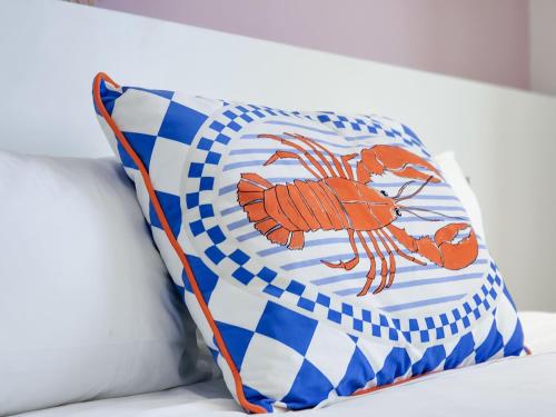 a blue and white pillow with a lobster on it at Palm Paradise - Boutique Guest House in Cape Town