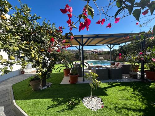 a garden with a pergola and a pool at GATU Villa Luna Casa de campo con piscina privada in Melegis