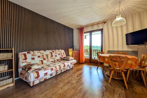 ein Schlafzimmer mit Bett und Tisch und ein Esszimmer in der Unterkunft Appartement 4 personnes au pied des pistes in Les Déserts