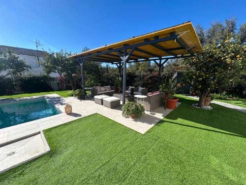 a garden with a pavilion and a swimming pool at GATU Villa Luna Casa de campo con piscina privada in Melegis