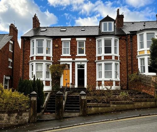 a red brick house with a yellow door at "Ivyholme" Superb Premium House in Central Durham Location in Durham