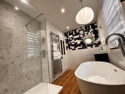 a bathroom with a white tub and a sink at "Ivyholme" Superb Premium House in Central Durham Location in Durham