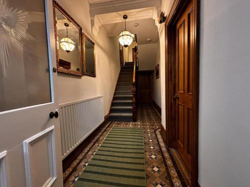 a hallway with a staircase with a green and white carpet at "Ivyholme" Superb Premium House in Central Durham Location in Durham
