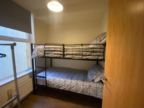 two bunk beds in a room with a window at City Apartment - Sleeps 4 & Free Parking in Belfast