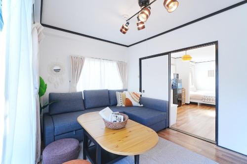 a living room with a blue couch and a table at Tomo House Yoyogi 302 - from 4 minutes station 代々木 302 駅から徒歩4分 in Tokyo