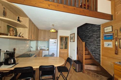 eine Küche mit einem Tisch und einer Ziegelwand in der Unterkunft Appartement familial au Revard vue sur le jardin d'enfant et pistes in Les Déserts