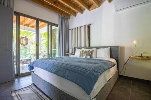 a bedroom with a large bed and a balcony at ProCab Kaya Apartments Cabarete in Cabarete
