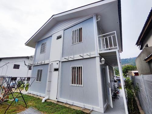 - un bâtiment blanc avec une porte et un balcon dans l'établissement Inap Cabin, à Teluk Bahang