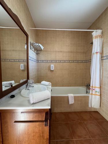 a bathroom with a sink and a tub and a mirror at Posada de Jose Mª El Tempranillo in Alameda