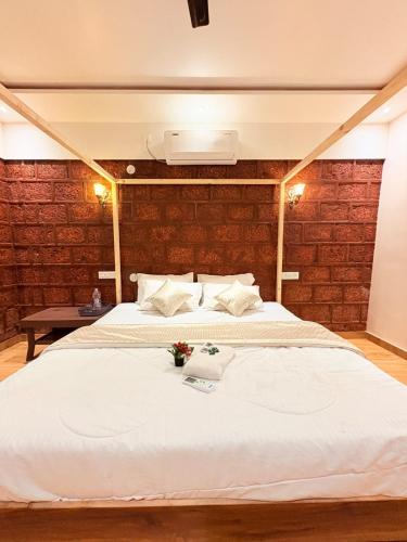 a bedroom with a large white bed in a room at CharDara Agrotourism & FarmStay in Mahabaleshwar