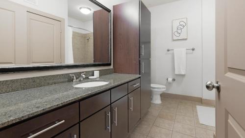 ein Badezimmer mit Waschbecken, Spiegel und Toilette in der Unterkunft Landing Apartments New Braunfels - Cedar Park in Gruene