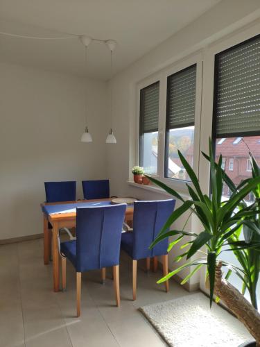 een eetkamer met een houten tafel en blauwe stoelen bij NaturZeit in Brunkensen in Brunkensen