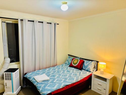 een kleine slaapkamer met een bed en een raam bij Affordable accommodation in Perth
