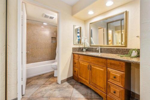 Un baño con lavabo, inodoro y espejo. en Papakea K103 · PK K103 Ocean views Condo | Lanai + AC + Pool, en Kaanapali