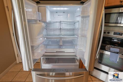 an empty refrigerator with its door open in a kitchen at 4BR Walk-in - Foosball Table - Fire Pit - FREE TICKETS INCLUDED - DV166 in Branson