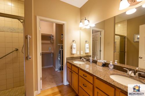 a bathroom with two sinks and a shower at 4BR Walk-in - Foosball Table - Fire Pit - FREE TICKETS INCLUDED - DV166 in Branson