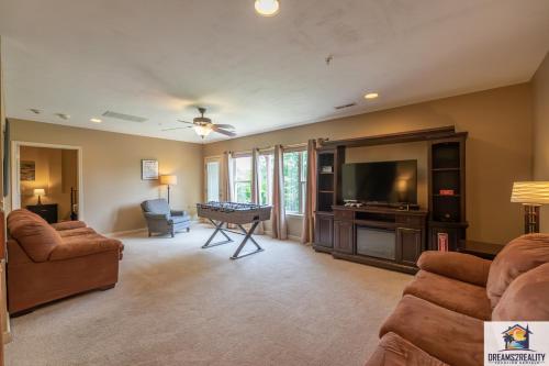 a living room with couches and a flat screen tv at 4BR Walk-in - Foosball Table - Fire Pit - FREE TICKETS INCLUDED - DV166 in Branson