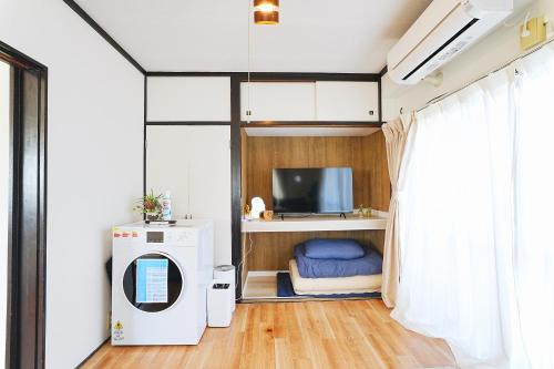 a small room with a tv and a desk with a tv at Tomo House Yoyogi 302 - from 4 minutes station 代々木 302 駅から徒歩4分 in Tokyo