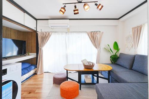 a living room with a couch and a table at Tomo House Yoyogi 302 - from 4 minutes station 代々木 302 駅から徒歩4分 in Tokyo