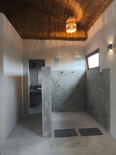 a room with a concrete wall and a window at Há Mar Chalés Corumbau in Corumbau