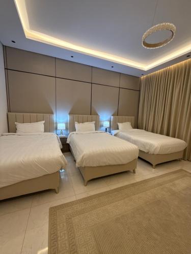 a bedroom with two beds and a large wall at شقة البدر in Medina