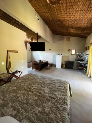 - une chambre avec un lit et une télévision dans l'établissement Há Mar Chalés Corumbau, à Prado