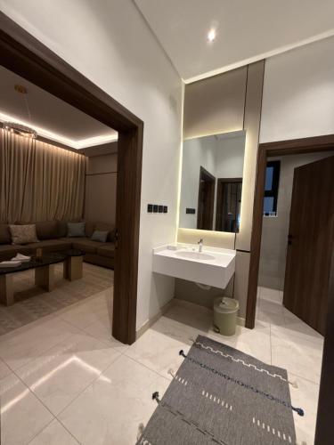 a bathroom with a sink and a mirror and a couch at شقة البدر in Medina