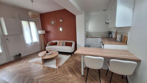 Una cocina y una sala de estar con mesa y sillas. en La Maison Des Pins, en Le Mans