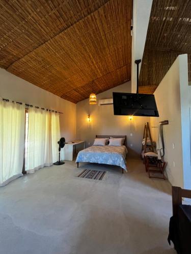 une chambre avec un lit et un plafond en bois dans l'établissement Há Mar Chalés Corumbau, à Prado