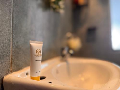 a bottle of sunscreen sitting on top of a bathroom sink at Harlem Suites in Kiambu