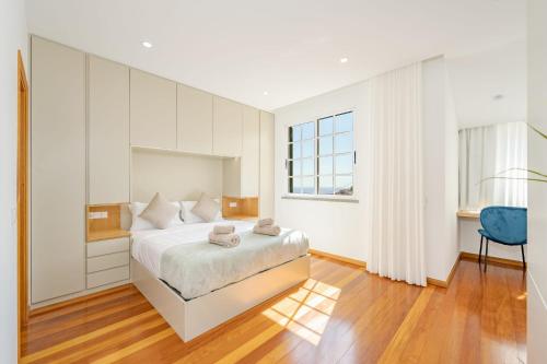 a white bedroom with a bed and a window at JPL - Preces Residential in Câmara de Lobos