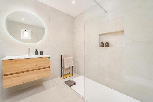 a white bathroom with a sink and a mirror at JPL - Preces Residential in Câmara de Lobos