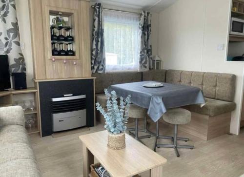 una sala de estar con una mesa y un sofá en La Campine, en Érezée