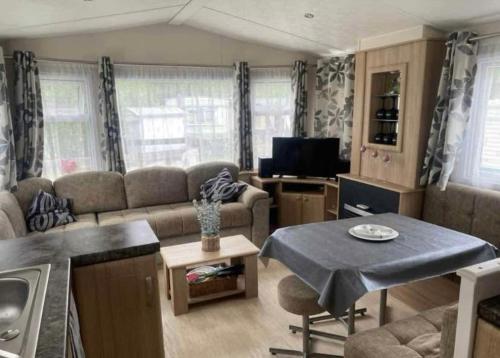 una sala de estar con un sofá y una mesa en La Campine, en Érezée