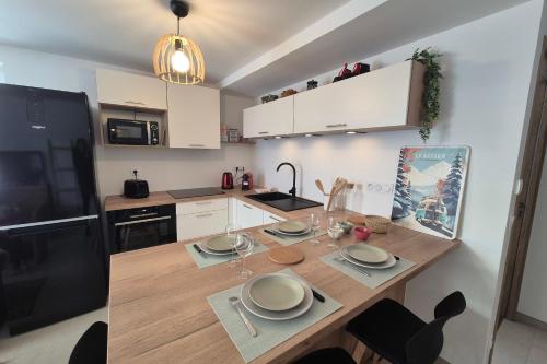 eine Küche mit einem Holztisch mit Gläsern darauf in der Unterkunft Magnifique appartement vue mont blanc in Les Déserts