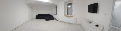 a living room with a couch and a television at Garsoniera in Craiova