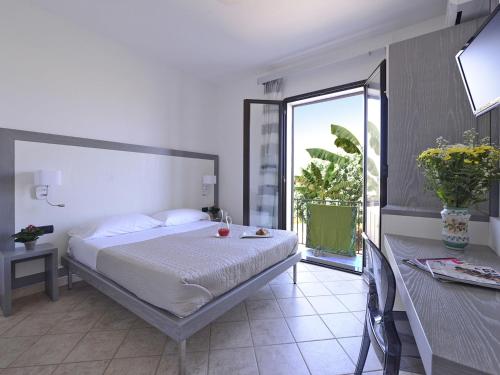 a bedroom with a bed and a large window at Oasis Hotel Residence Resort in Lampedusa