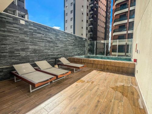 einen Balkon mit 2 Liegestühlen auf einem Gebäude in der Unterkunft Loft Design na Vila Mariana in São Paulo