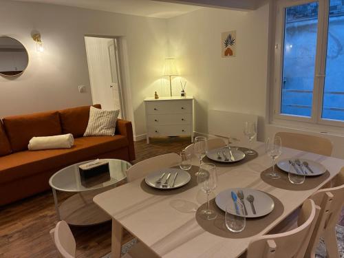 a living room with a table and a couch at Appartement chic & cosy - 6 couchages Angers in Angers