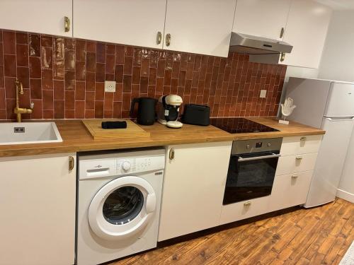 a kitchen with a washing machine and a sink at Appartement chic & cosy - 6 couchages Angers in Angers