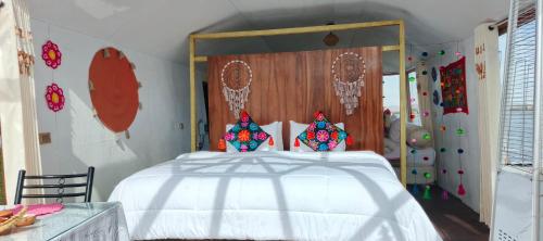 Un dormitorio con una cama blanca con cabecero de madera. en Titicaca amanecer, en Puno
