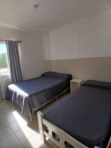 een slaapkamer met twee bedden en een raam bij DUPLEX BV in Bell Ville