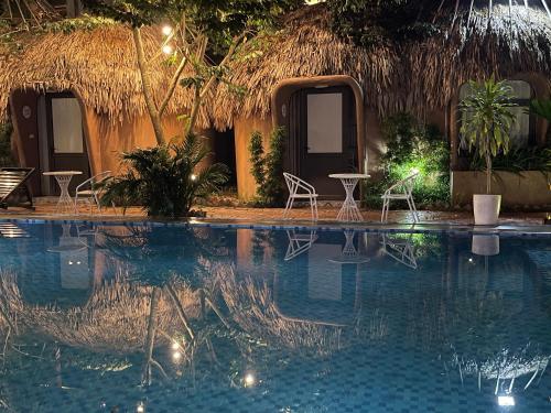 un resort con piscina con sedie e un edificio di Tam Coc Sky Bungalow a Ninh Binh