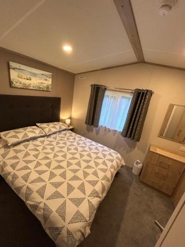 a bedroom with a large bed and a window at Isle of Wight Caravan in Shanklin